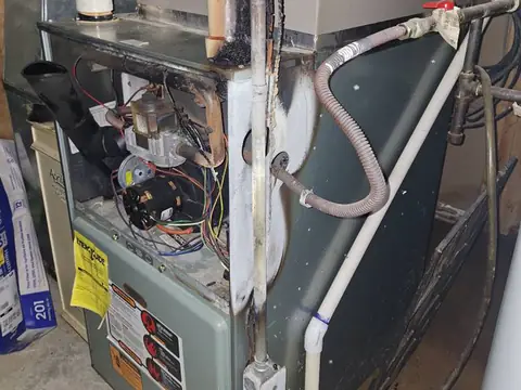 Furnace cabinet open with burners and wiring visible