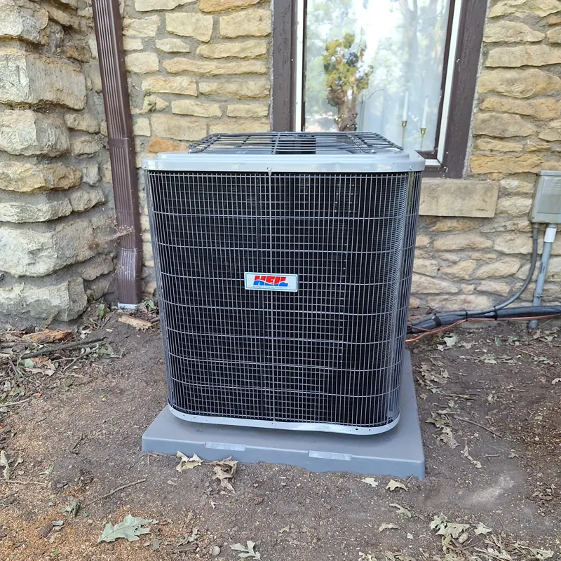 Heil condenser against a stone foundation