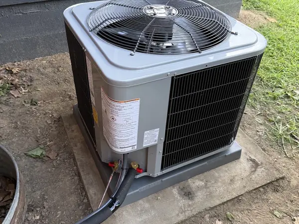 New outdoor unit installed beside a brick home